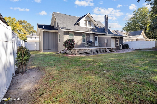 rear view of house with a wooden deck and a yard