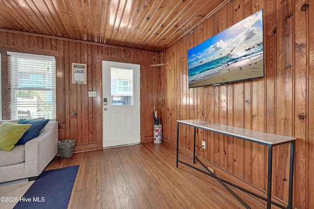 entrance foyer with a wealth of natural light, wooden ceiling, light hardwood / wood-style floors, and wooden walls