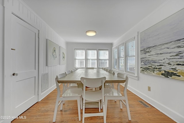 dining area with crown molding and light hardwood / wood-style flooring