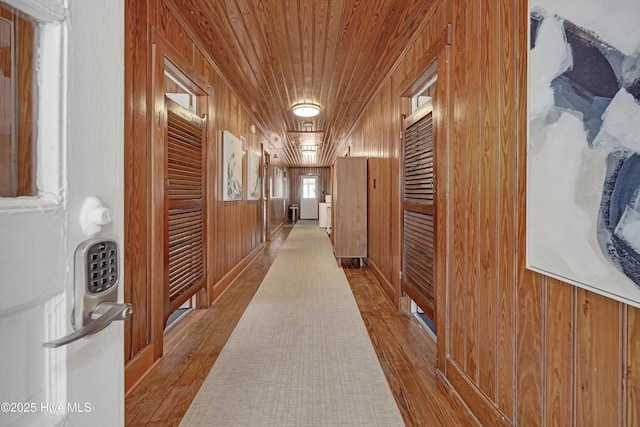 corridor with wood ceiling, wood-type flooring, and wooden walls