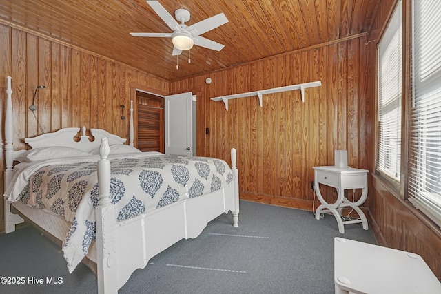 carpeted bedroom featuring wooden ceiling, ceiling fan, and wood walls