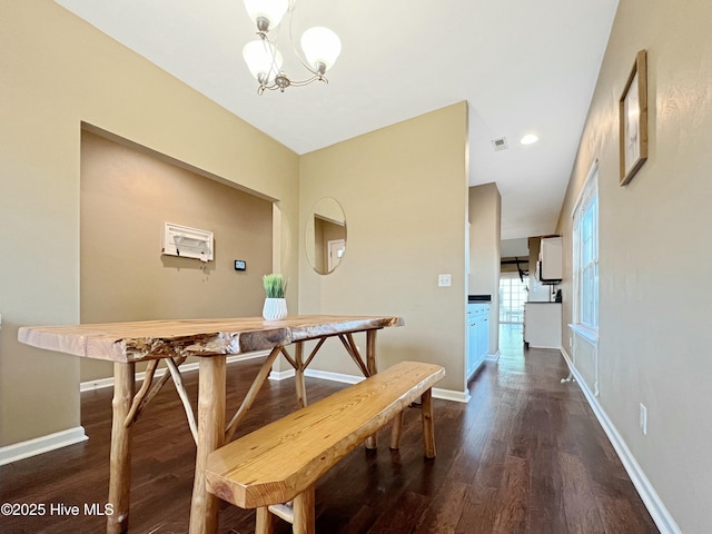 dining room with dark wood-type flooring and a chandelier