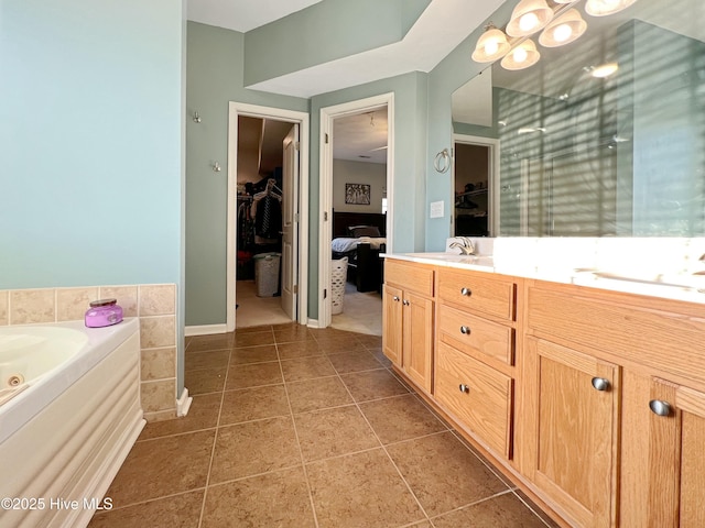 bathroom with vanity, a washtub, and tile patterned floors