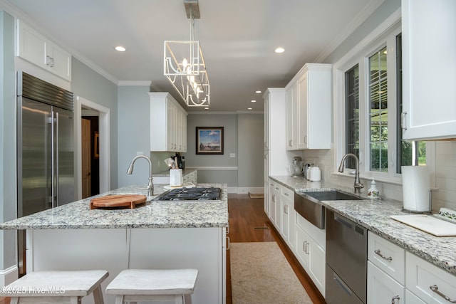 kitchen with appliances with stainless steel finishes, a center island, a breakfast bar area, and white cabinets