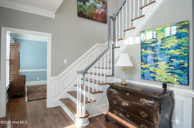 staircase with crown molding and wood-type flooring