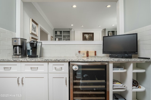 bar featuring white cabinetry, tasteful backsplash, light stone counters, crown molding, and beverage cooler