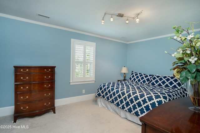 carpeted bedroom with ornamental molding and rail lighting