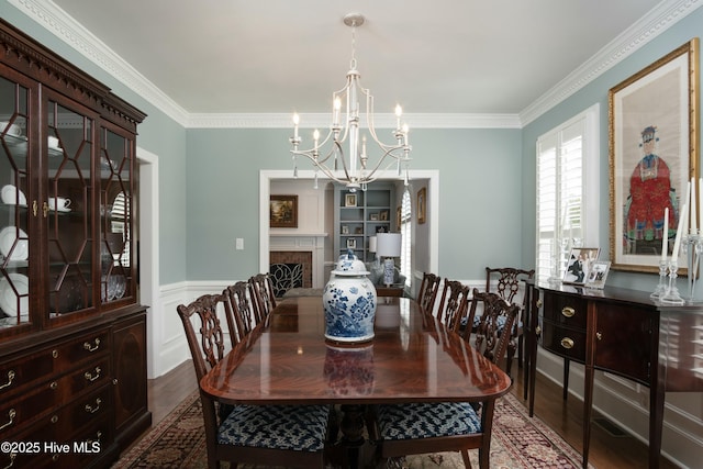 dining room featuring wood-type flooring, ornamental molding, and a chandelier