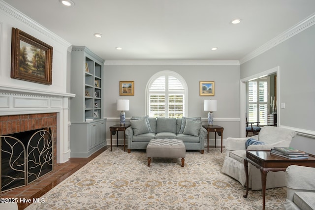 living room featuring crown molding, a fireplace, built in shelves, and a wealth of natural light