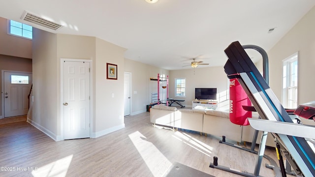 living area featuring wood finished floors, baseboards, a ceiling fan, and visible vents