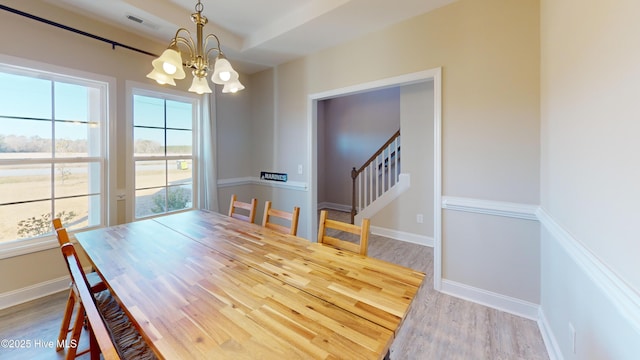 dining space featuring stairway, wood finished floors, a chandelier, baseboards, and visible vents