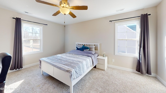carpeted bedroom featuring baseboards, visible vents, and ceiling fan