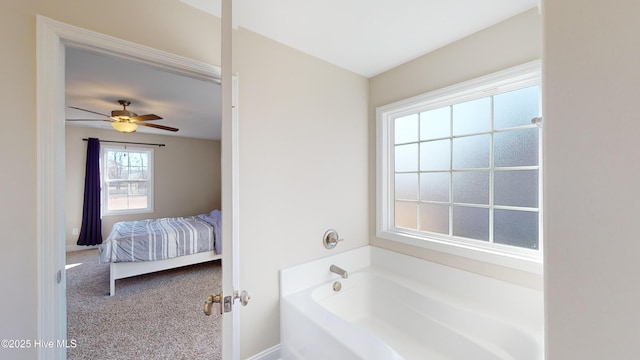 bathroom featuring ceiling fan and a tub to relax in