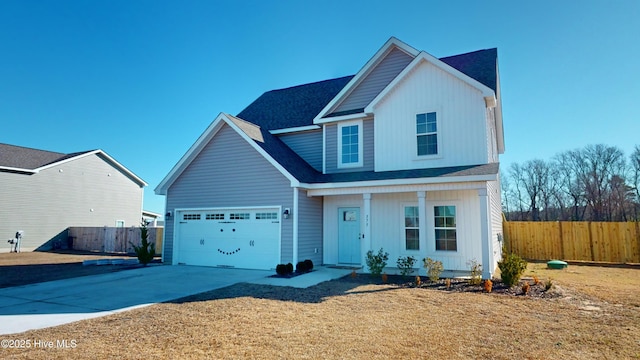 traditional-style house featuring fence, a shingled roof, driveway, and covered porch