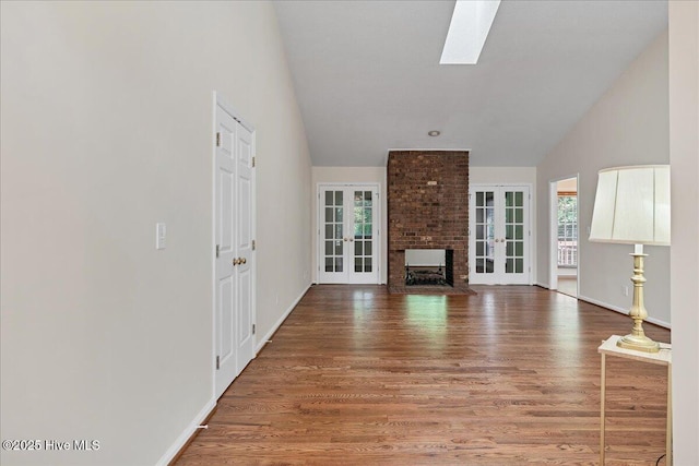 6 Elmhurst Pl, Pinehurst, NC 28374 - unfurnished living room with lofted ceiling, healthy amount of natural light, wood finished floors, french doors, and a brick fireplace