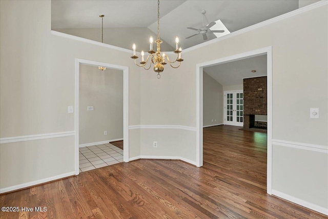 6 Elmhurst Pl, Pinehurst, NC 28374 - empty room with lofted ceiling, wood finished floors, a chandelier, ceiling fan, and a brick fireplace