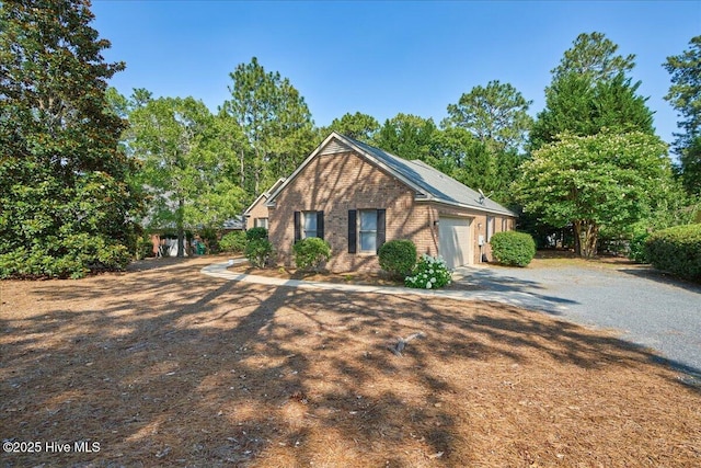 6 Elmhurst Pl, Pinehurst, NC 28374 - view of front of property with brick siding, driveway, an attached garage, and view of scattered trees
