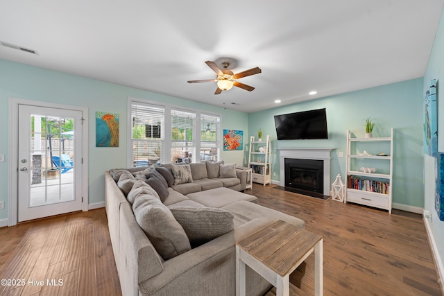 living room with ceiling fan and dark hardwood / wood-style flooring