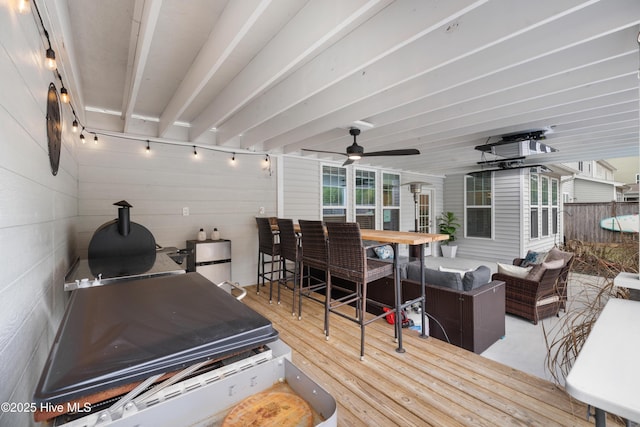 wooden deck featuring exterior bar, ceiling fan, and an outdoor hangout area