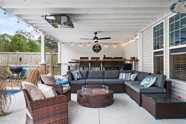 view of patio featuring ceiling fan and an outdoor living space with a fire pit