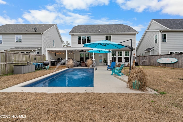 back of house with a patio, pool water feature, a yard, ceiling fan, and a fenced in pool