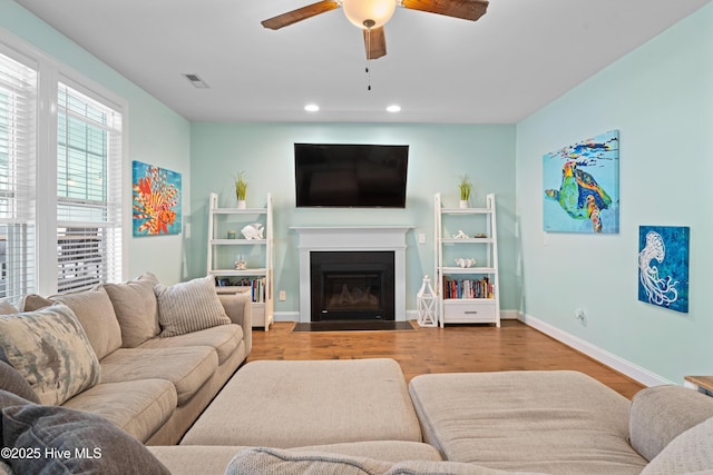 living room featuring ceiling fan and light hardwood / wood-style flooring