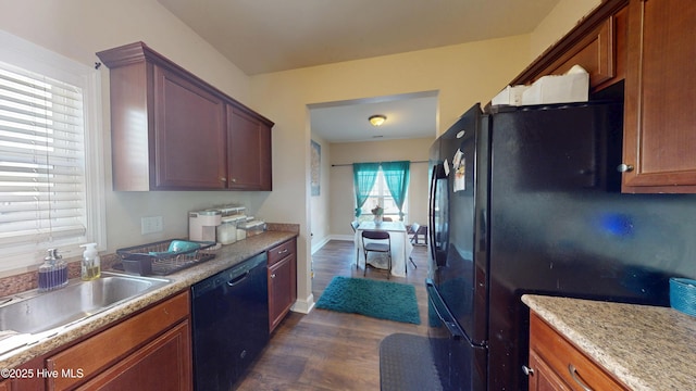 kitchen featuring sink, black appliances, dark hardwood / wood-style floors, and light stone counters