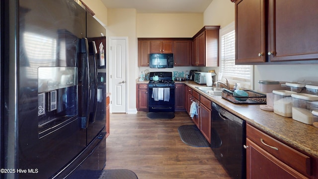 kitchen featuring dark wood-type flooring, sink, and black appliances