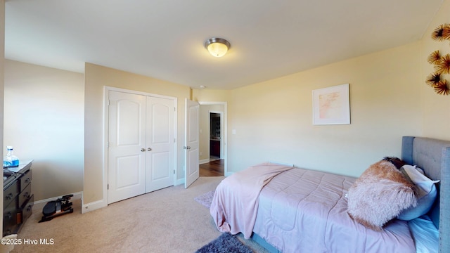 bedroom featuring light carpet and a closet