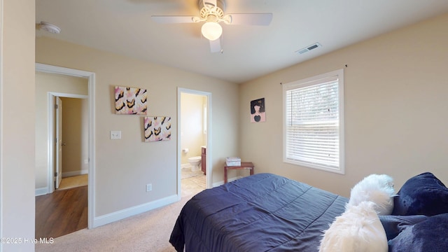 bedroom with ceiling fan, ensuite bath, and carpet floors