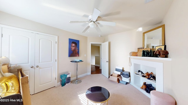 interior space featuring light carpet and ceiling fan