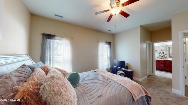 carpeted bedroom featuring ceiling fan and ensuite bath