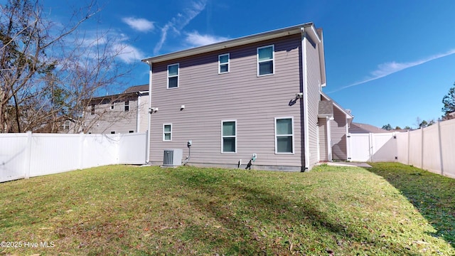 back of house featuring a yard and central AC