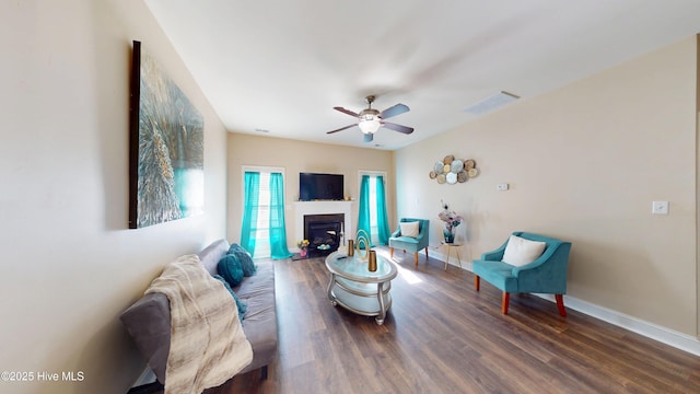 living room featuring ceiling fan and dark hardwood / wood-style floors