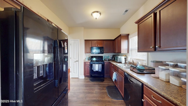 kitchen featuring sink, black appliances, and dark wood-type flooring