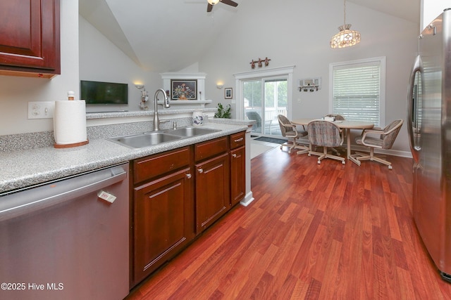 kitchen with sink, dark wood-type flooring, ceiling fan, stainless steel appliances, and decorative light fixtures