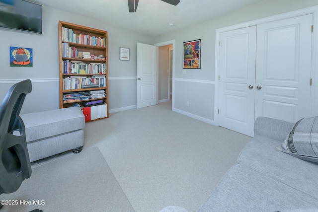 living area featuring light colored carpet and ceiling fan