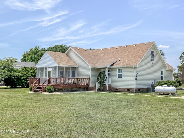 back of property with a deck, a sunroom, and a lawn