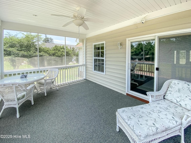 unfurnished sunroom featuring wood ceiling, ceiling fan, and a water view