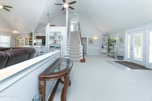 carpeted living room with ceiling fan, a healthy amount of sunlight, high vaulted ceiling, and built in features