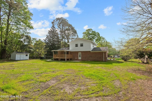 rear view of property with a wooden deck, a storage shed, a yard, an outdoor structure, and brick siding