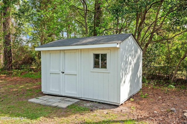 view of shed featuring fence