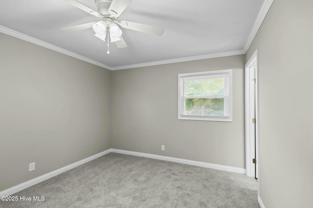 carpeted spare room with crown molding, ceiling fan, and baseboards