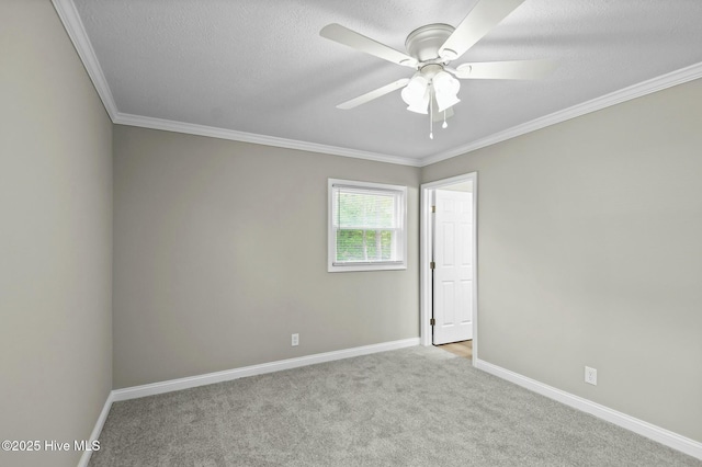 carpeted empty room featuring ornamental molding, baseboards, a ceiling fan, and a textured ceiling