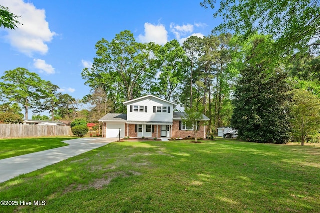 view of front of home with a garage, fence, brick siding, a front lawn, and driveway