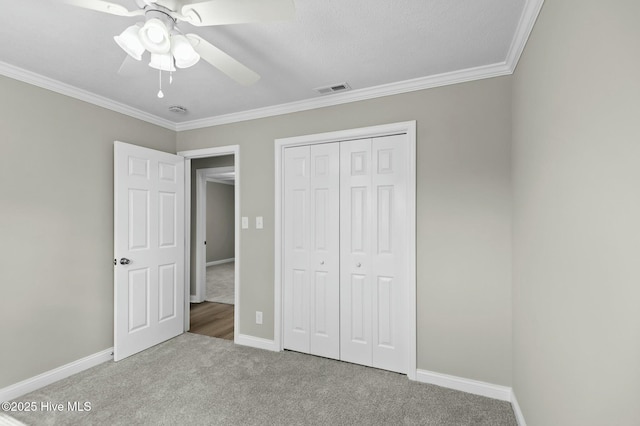 unfurnished bedroom featuring visible vents, baseboards, ornamental molding, and carpet floors