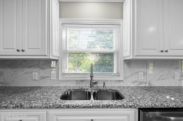 kitchen featuring a sink, decorative backsplash, and white cabinets