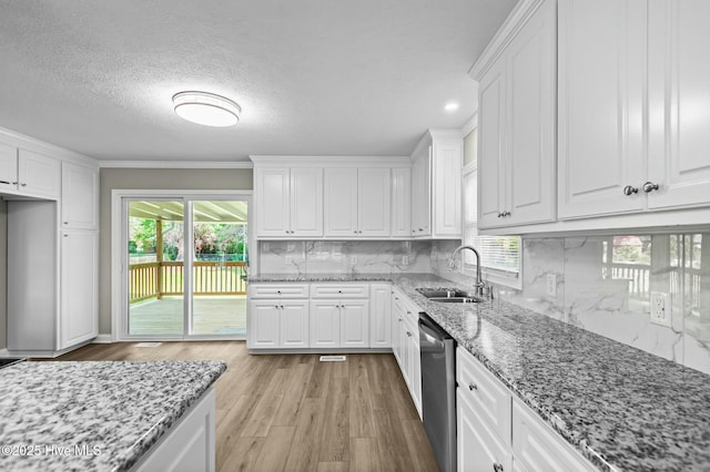 kitchen featuring a sink, white cabinetry, dishwasher, and a healthy amount of sunlight