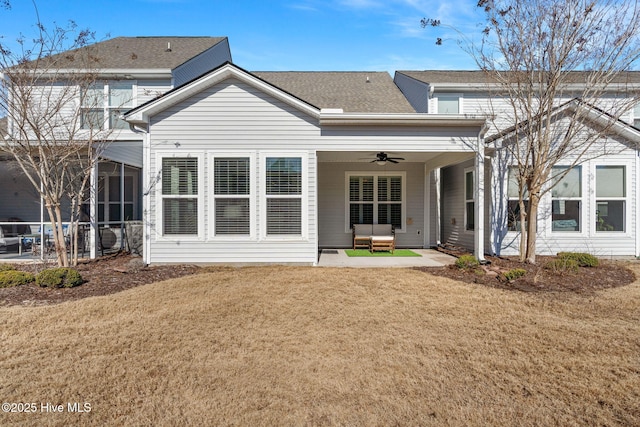 rear view of property with roof with shingles, a lawn, a sunroom, a patio area, and a ceiling fan