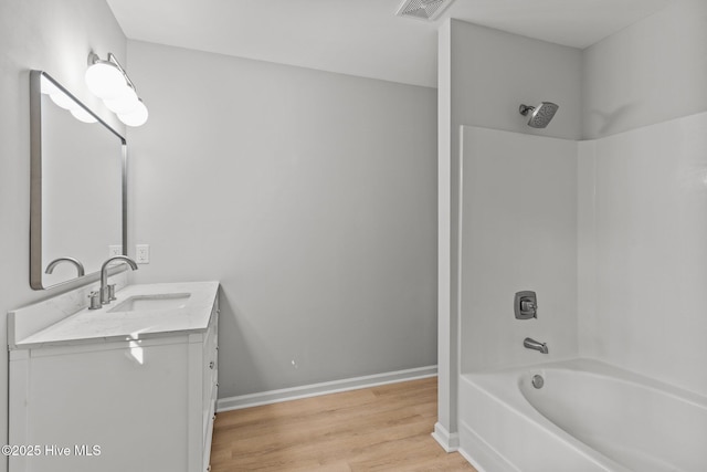 bathroom featuring shower / washtub combination, hardwood / wood-style floors, and vanity